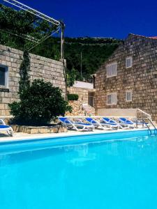 a group of blue chairs sitting in a swimming pool at Apartments Anamaria in Dubrovnik