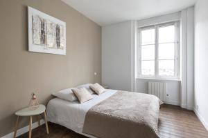 - une chambre blanche avec un lit et une fenêtre dans l'établissement Zen et design, proche Cité Corsaire, à Saint-Malo