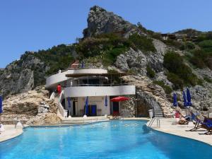 a resort with a swimming pool and a mountain at Terrazza Marina in Porto Santo Stefano