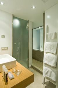 ein Bad mit einer Badewanne, einem Waschbecken und einer Dusche in der Unterkunft Perantzada Hotel 1811 in Vathy