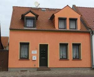 een oranje huis met ramen en een deur bij Ferienwohnung Schweizer in Coswig