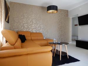 ein Wohnzimmer mit einem Sofa und einem Tisch in der Unterkunft Apartman Nia in Zadar