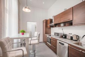 uma cozinha com armários de madeira e um balcão branco em Budapest Broadway Apartment em Budapeste