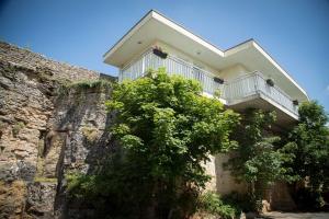 a house on the side of a stone wall at Hôtel Les Hauts de Meursault in Meursault