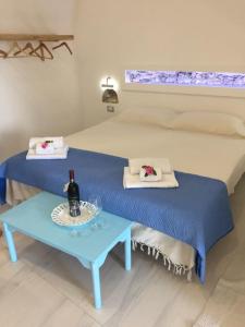 Pokój z łóżkiem ze stołem i butelką wina w obiekcie Suite sul mare w mieście Giardini Naxos