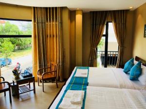 a bedroom with a large bed and a large window at Hồng Hạc Hotel in Tuy Hoa