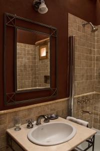 a bathroom with a sink and a mirror and a shower at Posada de Luz in Tilcara