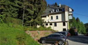 a car parked in front of a house at Pension Waldfrieden in Wolkenstein