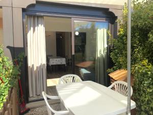 una mesa blanca y sillas en un patio en Appartement rénové aux portes de St tropez, en Gassin