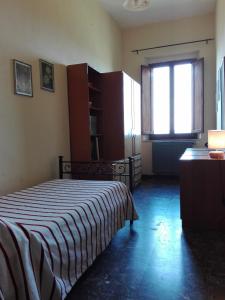 スカルリーノにあるAppartamento Felixのベッドルーム1室(ストライプ毛布、窓付)