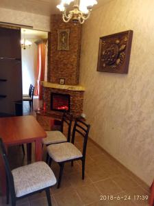شقة شيلمان الفندقية في أوديسا: غرفة طعام مع طاولة وكراسي ومدفأة