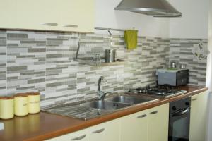 una cucina con lavello e fornello di B&B Myrta Maria a Cagliari