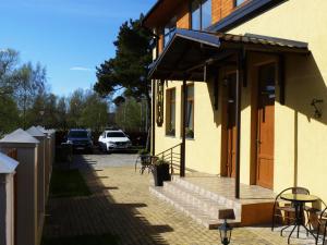 a building with a porch and a table and chairs at Viesu nams "Svīre-10" in Ventspils