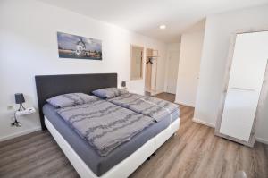 ein Schlafzimmer mit einem großen Bett in einem weißen Zimmer in der Unterkunft Pension LPG-Hof in Großpösna