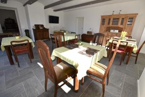 a dining room with tables and chairs with green table cloth at Pension LPG-Hof in Großpösna