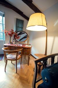 a room with a desk and a table with a lamp at Villa Fausta B&B in Trieste