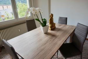 een houten tafel met een vaas met bloemen erop bij appartamento benaco in Riva del Garda