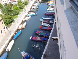 a group of boats are docked in a canal at Hotel Caldin's in Chioggia