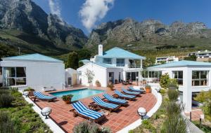 a villa with a swimming pool and mountains in the background at Diamond House Guesthouse in Cape Town