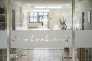 Smart Liv'in Laabnerhof في لابن: باب زجاجي عليه علامة مكتوب عليها الاثراء القرمزي
