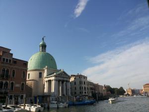 a building with a green dome next to the water at Venice Vacation House in Marghera