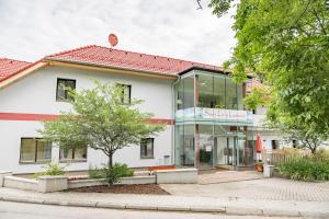 un edificio blanco con ventanas de cristal y un árbol en Smart Liv'in Laabnerhof en Laaben