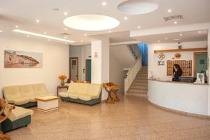 a lobby of a hospital with couches and a woman at Hotel Cristalda in Vieste