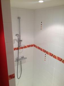 a shower in a bathroom with white tiles at Les Terrasses de Rochetaillée in Rochetaillée