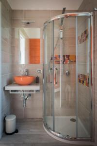 uma casa de banho com uma cabina de duche em vidro e um lavatório. em L'Agrumeto em Procida