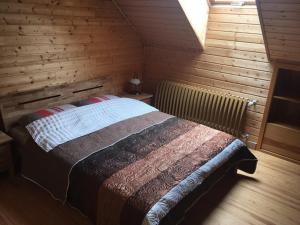 1 dormitorio con 1 cama en una habitación de madera en Amoliņi, en Mērsrags