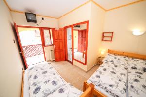 a small bedroom with a bed and a balcony at Fűzfa Vendégház in Bogács +29 photos