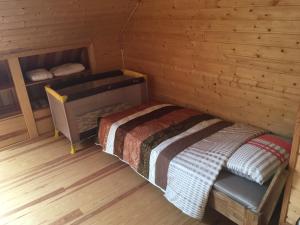 a small room with a bed in a log cabin at Amoliņi in Mērsrags