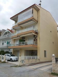 a building with a car parked in front of it at Jordan's Neoi Epivates Appartment by the Beach in Neoi Epivates
