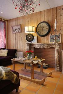 a living room with a table and a clock on the wall at La Pradella in Bolquere Pyrenees 2000