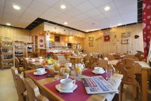 une salle à manger avec une table et des chaises ainsi qu'un restaurant dans l'établissement La Pradella, à Bolquère-Pyrénées 2000