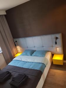 een slaapkamer met een bed met een wit hoofdeinde bij Porta Mare Apartamenty Leśne Tarasy II in Dziwnówek