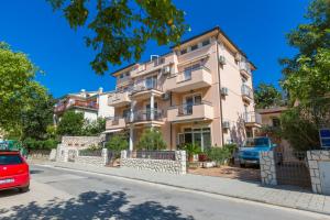 an apartment building with a car parked in front of it at Amfora Apartments in Crikvenica
