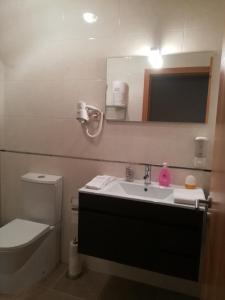 a bathroom with a sink and a toilet and a mirror at Casa do Azibo in Santa Combinha