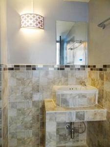 ein Bad mit einem Waschbecken und einem Spiegel in der Unterkunft Kongkam House in Mae Sai
