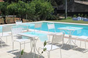 een tafel en stoelen naast een zwembad bij Il Gelso Nero in Vittoria