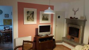 a living room with a tv and a fireplace at Il Molino Di Serravalle in Bibbiena