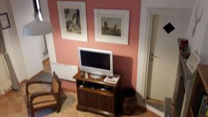 a living room with a tv on a wooden table at Il Molino Di Serravalle in Bibbiena