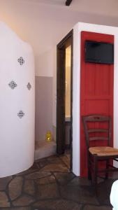 Zimmer mit einer roten Tür, einem Tisch und einem Stuhl in der Unterkunft Aperanto Galazio in Skopelos