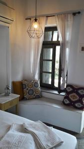 1 dormitorio con cama y ventana en Aperanto Galazio, en Skopelos Town
