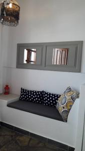 un sofá blanco con almohadas en una habitación en Aperanto Galazio, en Skopelos Town