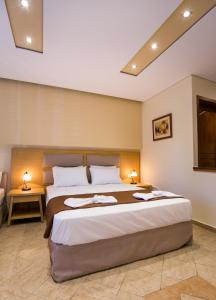 1 dormitorio con 1 cama grande y 2 lámparas en Villa Katerina, en Potos