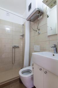 baño con aseo rosa y lavamanos en Apartment Francesco, en Šibenik