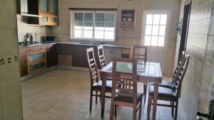 a kitchen with a wooden table and chairs in it at casa chaveca in Portimão