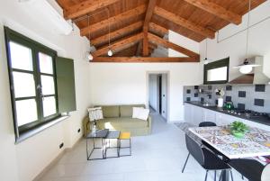uma cozinha e sala de estar com um sofá e uma mesa em Cascina dei Giacinti em Nizza Monferrato