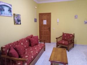 プラヤ・デ・サンティアゴにあるApartamentos La Bandaのリビングルーム(ソファ、椅子、テーブル付)